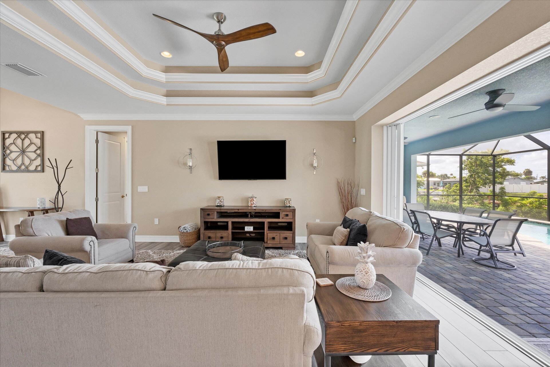 Large living room overlooking pool. Living room features comfy, ample seating and large 65-inch Smart TV
