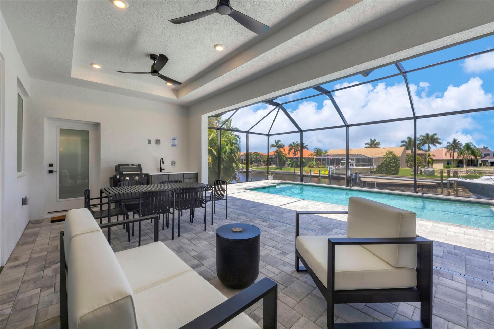 The best of Florida outdoor living. Lanai with outdoor kitchen overlooking the sparkling private pool and canal