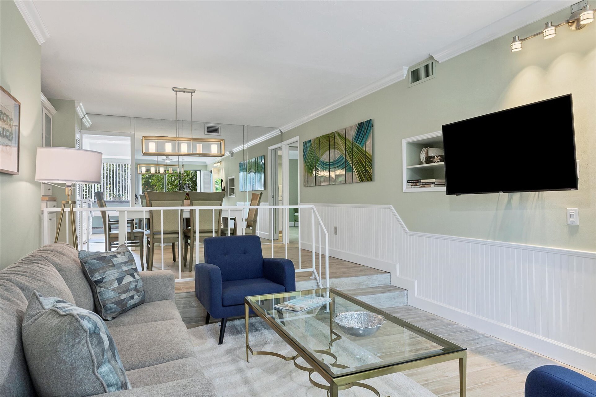 Living room with 55-inch TV, balcony access, and queen sofa bed