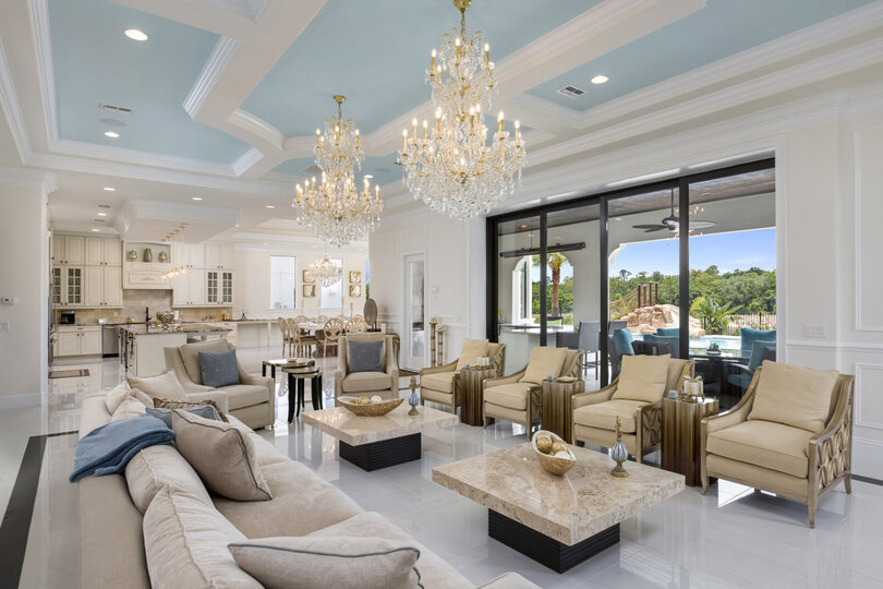 The open living space boasts crystal chandeliers and granite end tables
