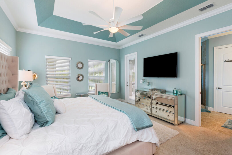 The master bedroom features a King size bed, en-suite bathroom, and private balcony with view to the pool area