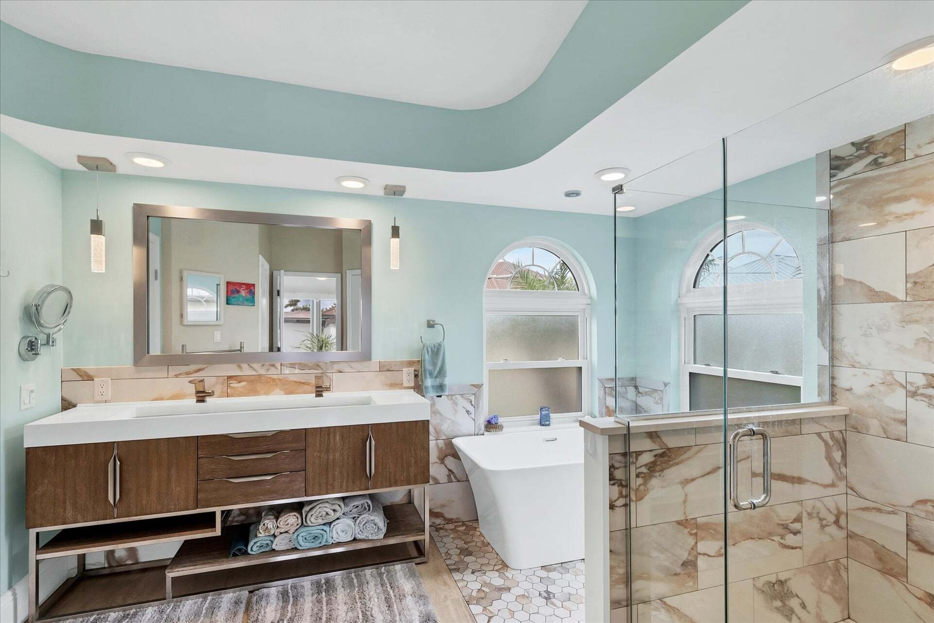 Primary attached bathroom with large walk-in shower, soaking tub, and double vanities