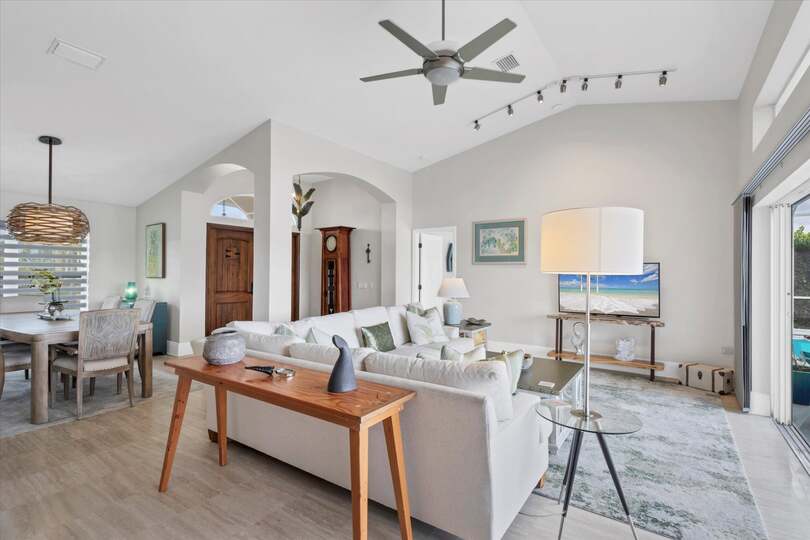 Family room overlooking sparkling pool and canal beyond. Features comfy seating and a 56-inch Smart TV