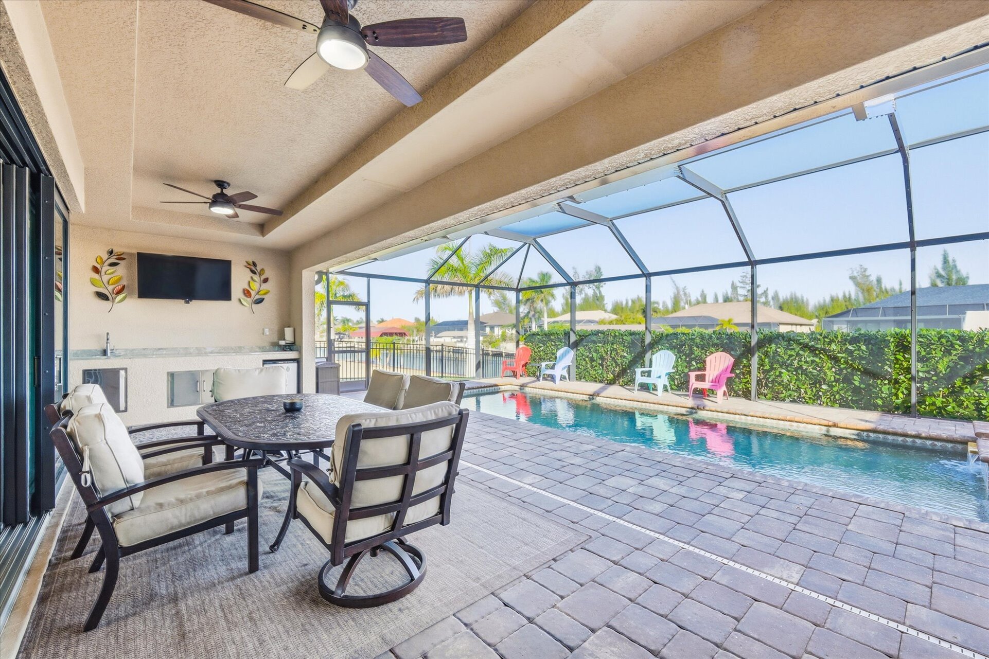 Large outdoor living area overlooking the sparkling pool and canal. Great for entertaining. Features a dining table that seats 6, BBQ grill, outdoor kitchen, Conversation furnite set, and 43" Smart TV
