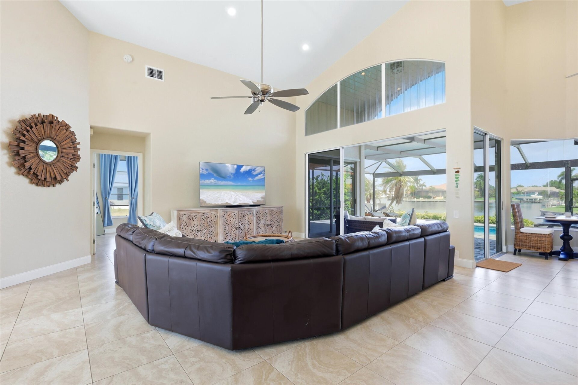 Family room with large sectional sofa, lanai access and 75-inch Smart TV