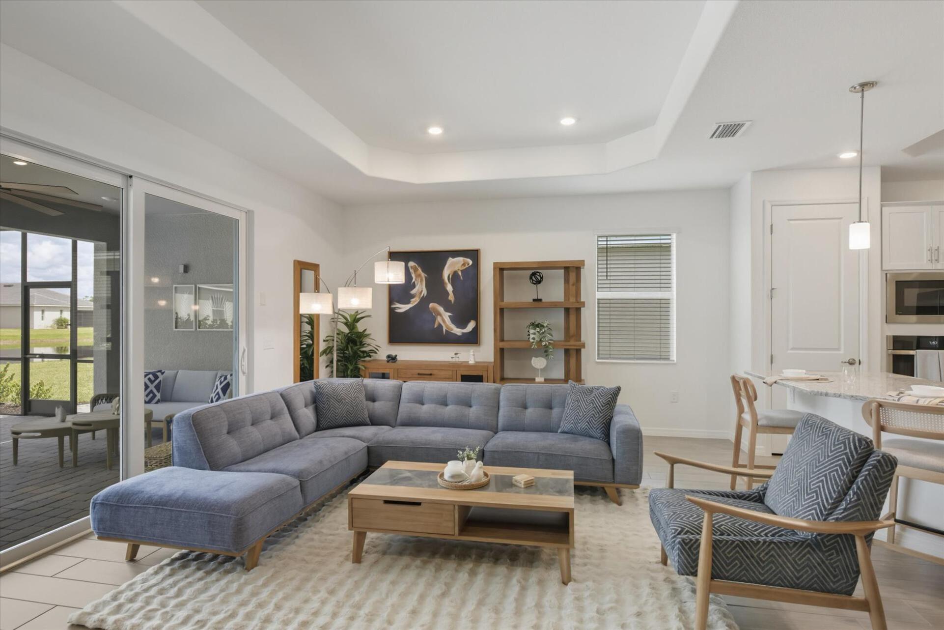 Living room overlooking the sparkling pool. Features ample seating and 85-inch Smart TV