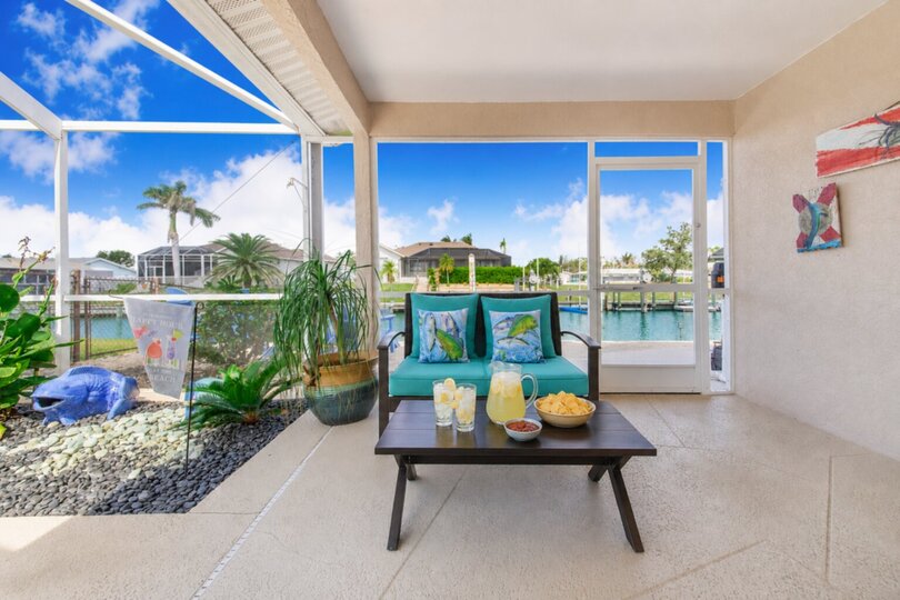 Large outdoor living space with sparkling pool overlooking the canal