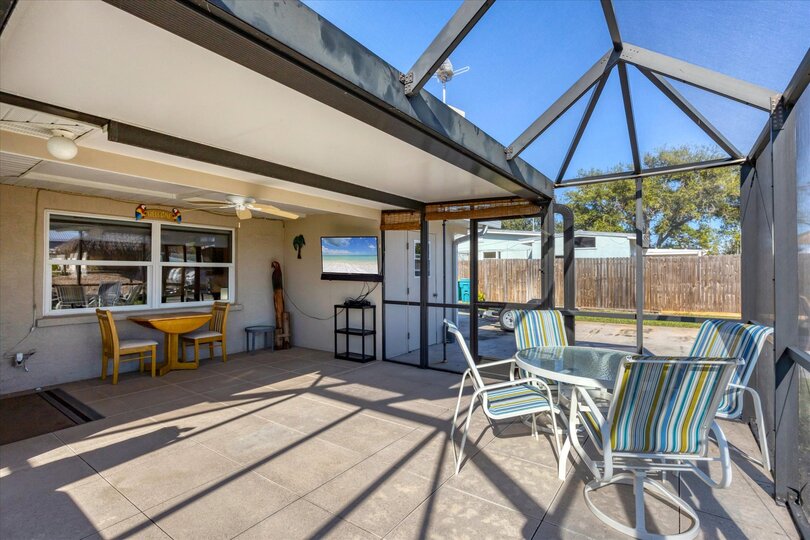 Screened-in patio overlooking the canal with private hot tub that seats 6 and outdoor dining area
