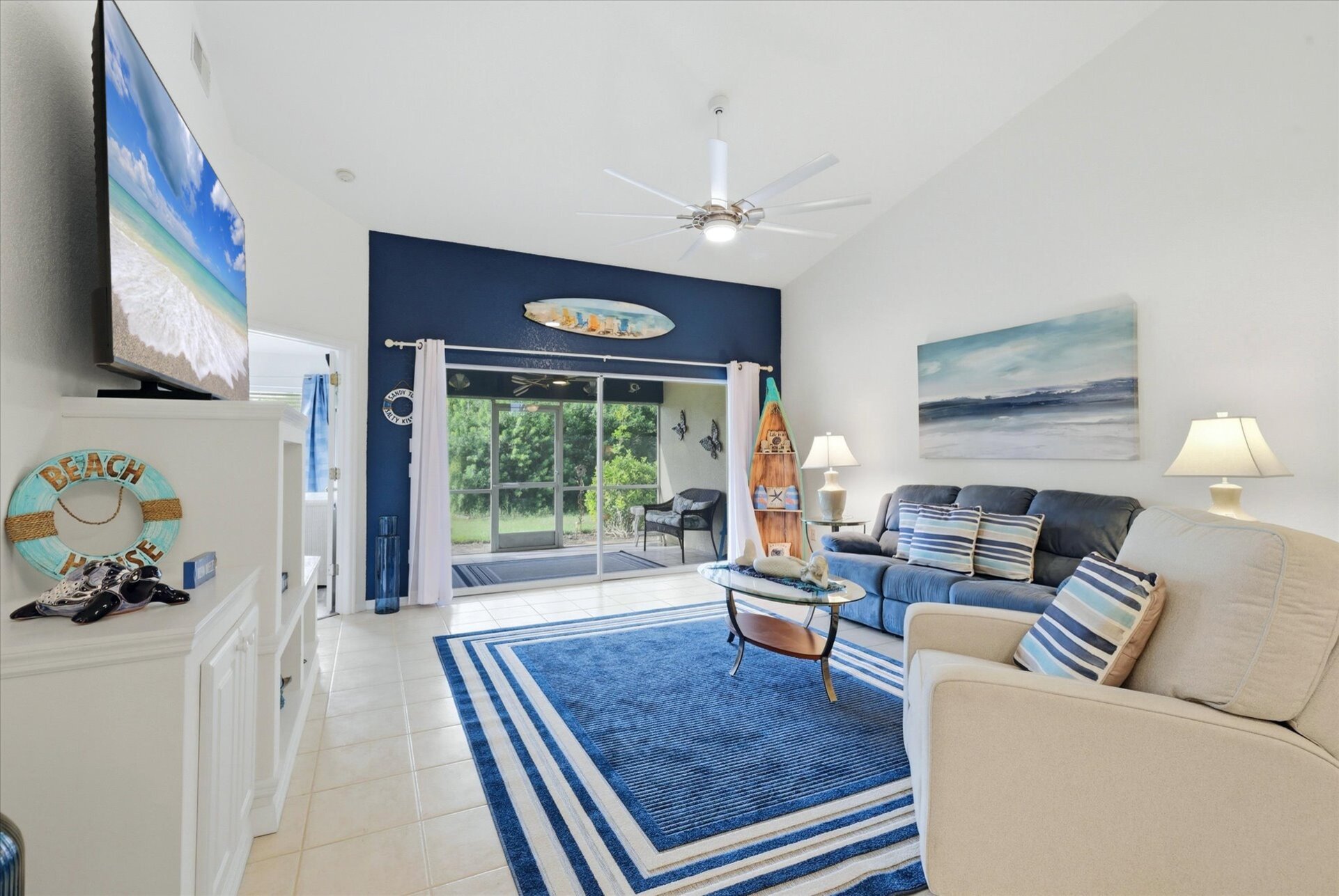 Large living space includes patio access overlooking the pond, and 75-inch Smart TV