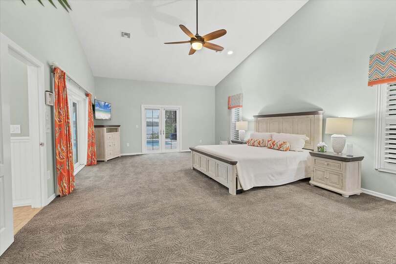 Primary bedroom features a king bed, lanai access, beautiful en suite, and 48-inch Smart TV
